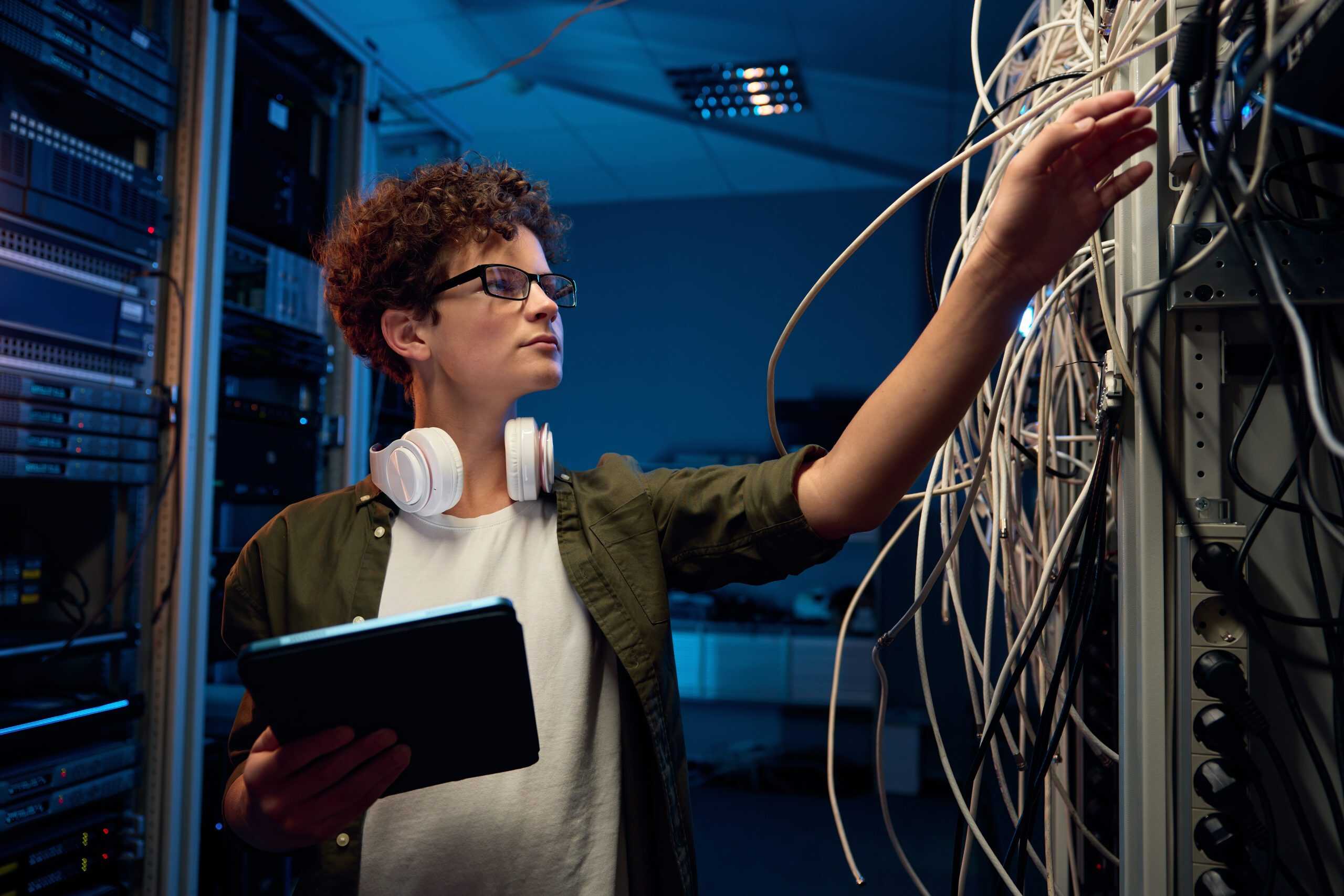 IT student checking the network in a server room, network defender micro credential